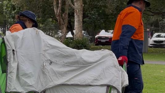Gold Coast City Council workers remove abandoned tents from Carey Park at Southport.
