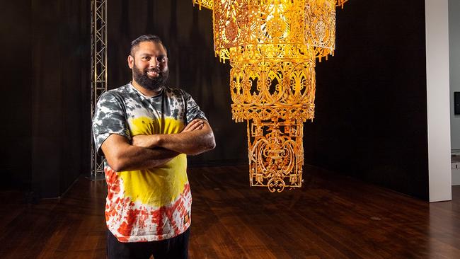 Dennis Golding with detail from his art installation Casting Shadows [Chandelier] 2022, at the Adelaide Biennial of Australian Art. Picture: Saul Steed