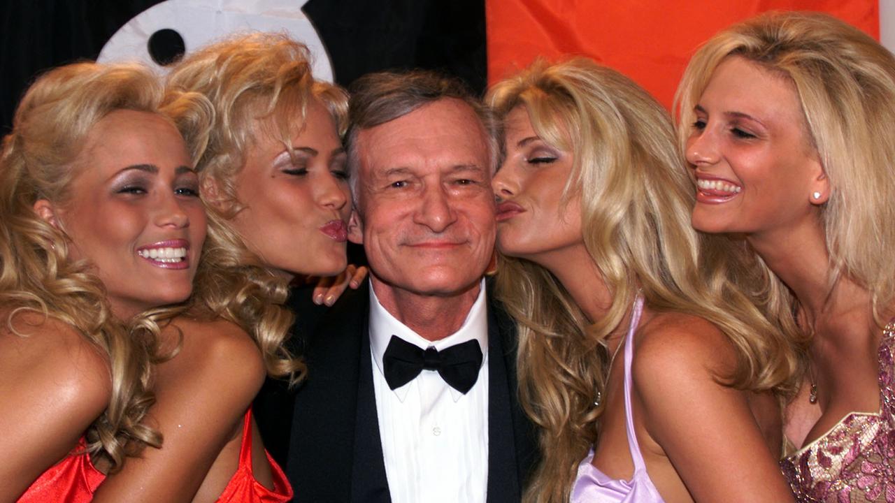 Playboy founder and editor in chief Hugh Hefner basks in the kisses of his playmates in Cannes May 14, 1999. (AP Photo/Laurent/Rebours) france headshot