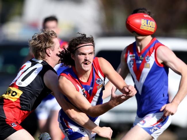 South Barwon’s Doyle Madigan slips a handball out under pressure. Picture: Mike Dugdale