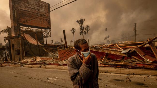 A man walks past a fire-ravaged business after the Eaton Fire swept through. Picture: AP