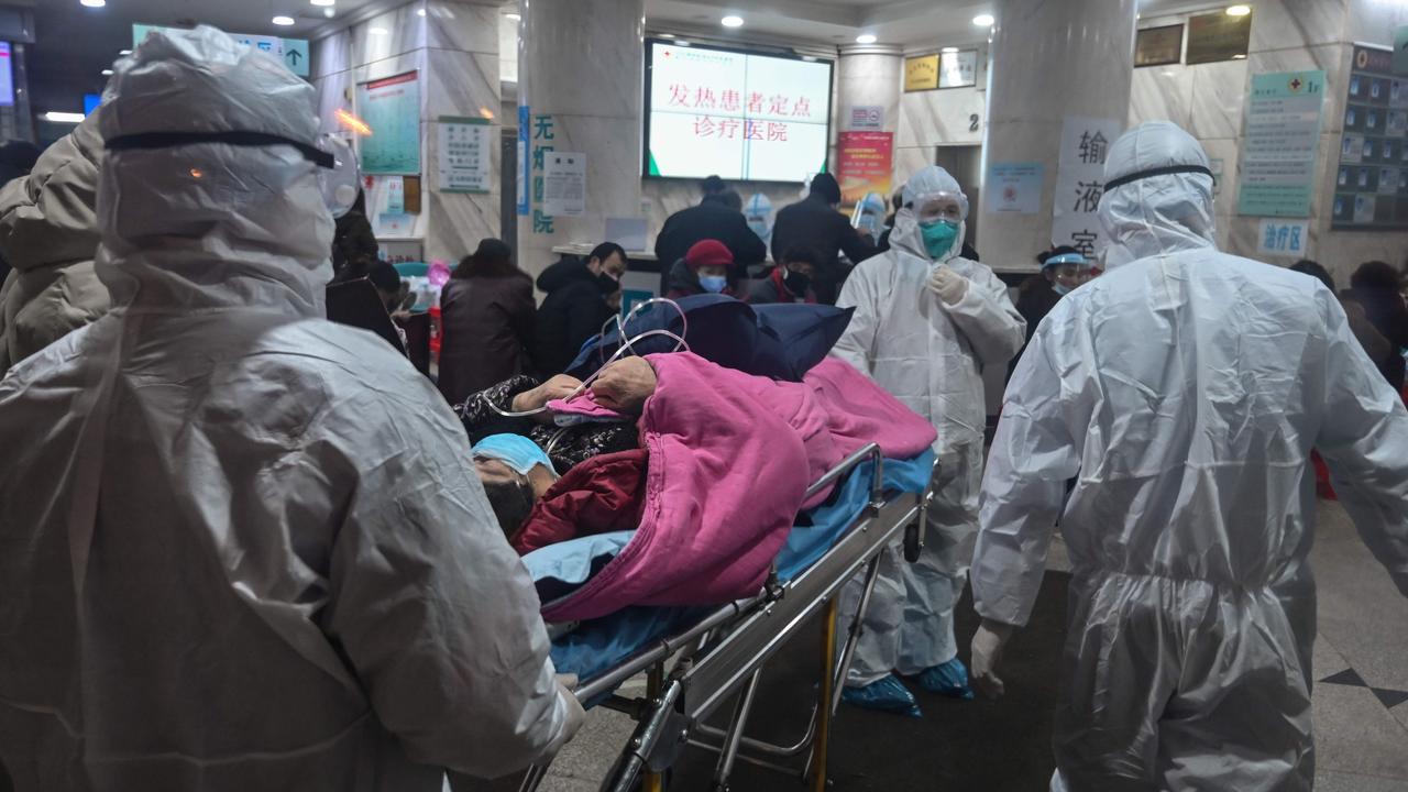 Medical staff wearing protective clothing with a patient at the Wuhan Red Cross Hospital in Wuhan. Picture: Hector Retamal/AFP