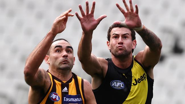 MELBOURNE, AUSTRALIA - AUGUST 21, 2021:   Richmonds Jack Graham and Shaun Burgoyne of the Hawks    during the round 23 AFL match between the Richmond and Hawthorn at the MCG, on August 20, 2021, in Melbourne, Australia. (Photo by Michael Klein)