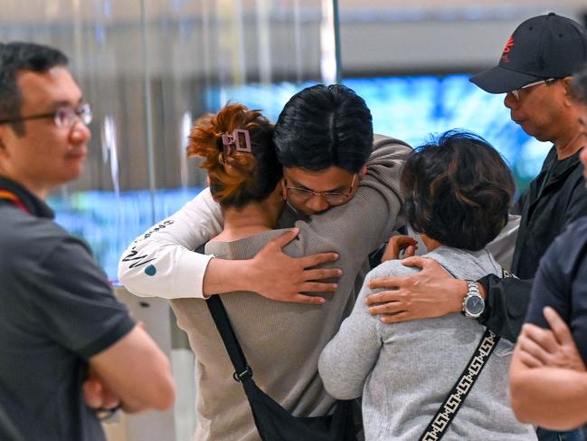 Passengers hug loved ones upon arrival at Changhi Airport in Singapore. Picture: AFP