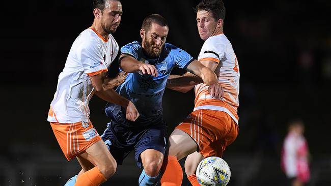 Sydney FC midfielder Josh Brillante looks to get between Cairns FC’s Jamie Carroll and Crios O'Hare on Tuesday night. Picture: Getty Images