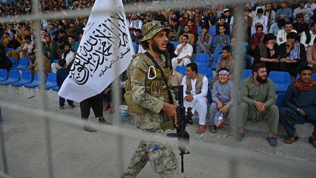 A Taliban fighter keeps watch on the crowd at a cricket match in Kabul