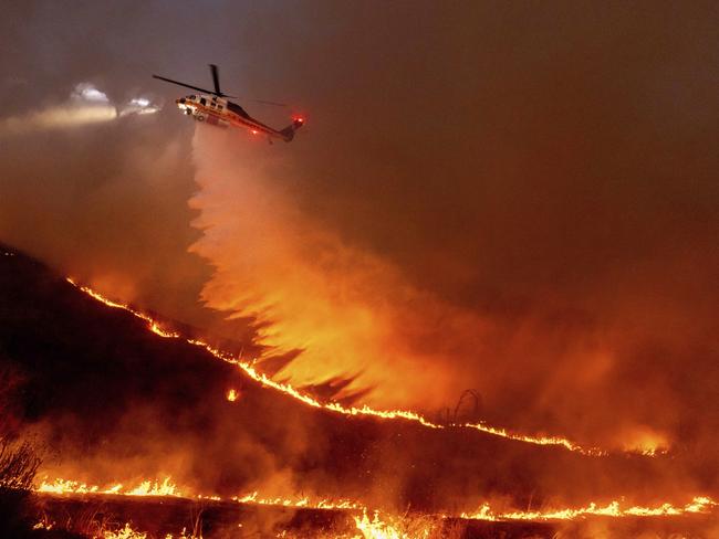 Water is dropped by helicopter on the Kenneth Fire in the West Hills section of Los Angeles. Picture: AP Photo/Ethan Swope