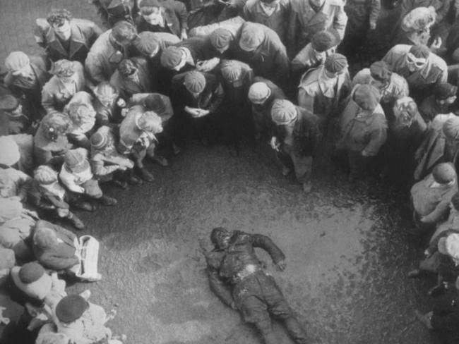 Hungarians gather around the body of a fighter killed in the 1956 Budapest uprising.