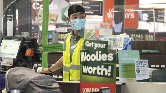 A staff member at the checkout at Woolworths in South Melbourne Picture: David Geraghty