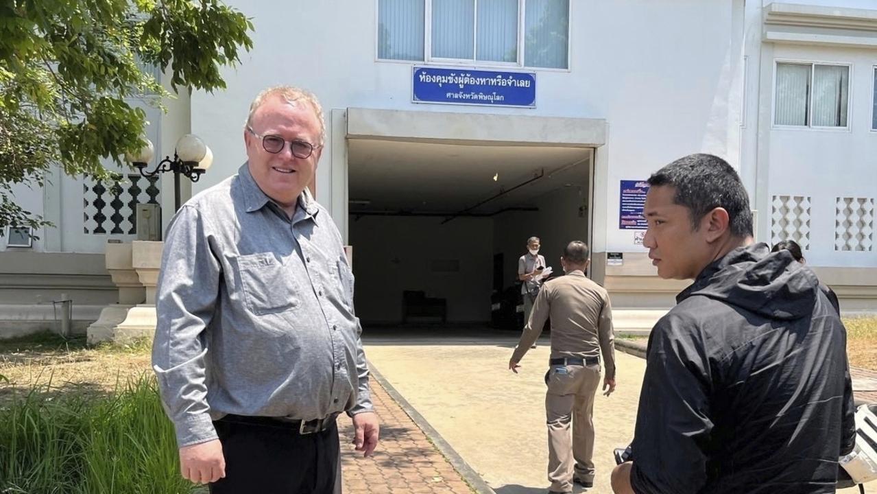 US political science lecturer Paul Chambers, left, of Thailand's Naresuan University, stands outside the police station in Phitsanulok, Thailand, where he was arrested. Picture: AP