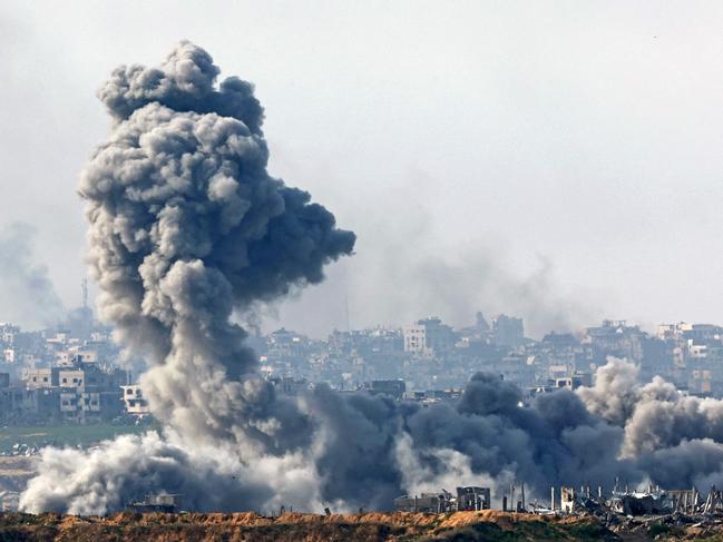 TOPSHOT - This picture taken from the Israeli side of the border with the Gaza Strip shows smoke plumes rising from explosions above destroyed buildings in the northern Gaza Strip on January 14, 2025, amid the ongoing war between Israel and Hamas. (Photo by Jack GUEZ / AFP)