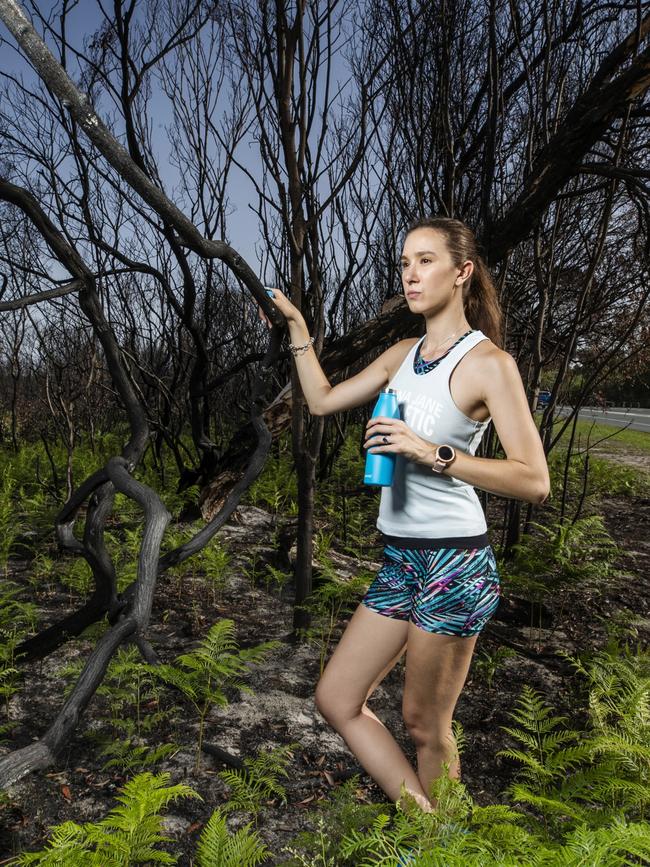 Katie Panic, 24, stands among the regrowth in one of the spots devastated by bushfires at Peregian. Picture: Lachie Millard