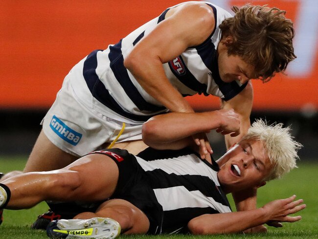 MELBOURNE, AUSTRALIA - APRIL 02: Tom Atkins of the Cats wrestles with Jack Ginnivan of the Magpies during the 2022 AFL Round 03 match between the Collingwood Magpies and the Geelong Cats at the Melbourne Cricket Ground on April 02, 2022 In Melbourne, Australia. (Photo by Dylan Burns/AFL Photos via Getty Images)