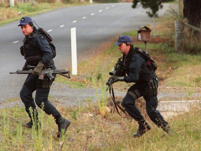 April 28, 1996: Special Operations police run for cover at the shooting scene.