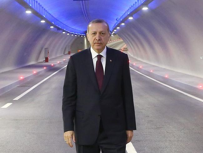 A handout picture released by the Turkish presidential press office shows Turkish President Recep Tayyip Erdogan posing in the tunnel on December 20, 2016 in Istanbul, during the opening cerenomy of the Avrasya (Eurasia) Tunnel, the first ever road tunnel underneath the Bosphorus Strait in Istanbul from Europe to Asia and the latest project in the Erdogan's plan of transforming Turkey's infrastructure. Turkey in October 2013 opened the Marmaray rail tunnel underneath the iconic waterway, the first link beneath the waters that divide Europe and Asia. But the new Avrasya (Eurasia) Tunnel is the first tunnel for cars underneath the Bosphorus and aims to relieve congestion in the traffic-clogged Turkish megacity. Other schemes, which Erdogan boasts are his 