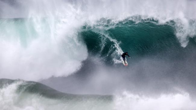 Surfers enjoying the large swell at Wedding Cake Island off Coogee. Picture: Jonathan Ng.