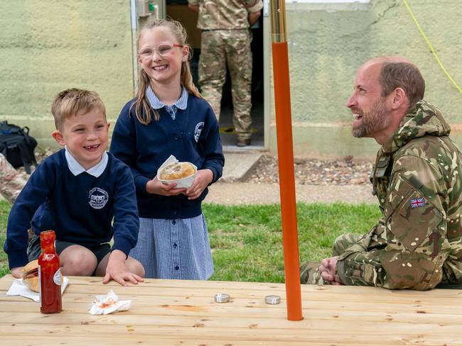 Father-of-three Prince William chats with the children of members of staff during a visit to the Army Air Corps, in Wattisham, eastern England. Picture: AFP