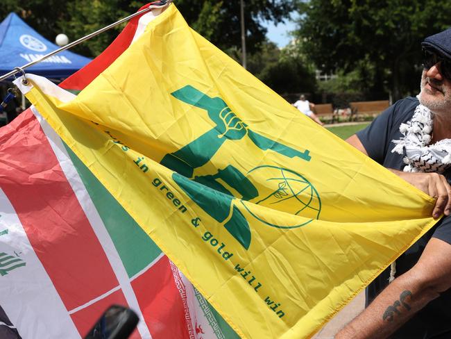 SYDNEY, AUSTRALIA - NewsWire Photos OCTOBER 6, 2024: A protester pictured holding  a yellow flag that looks like the Hezbollah flag but has ned Kelly on it at the protest in Hyde Park. Protestors gather at Hyde Park in Sydney's CBD to demand an end to the ongoing war and Israel's current occupation of Gaza, and the escalating Israel-Lebanon conflict.Picture: NewsWire / Damian Shaw