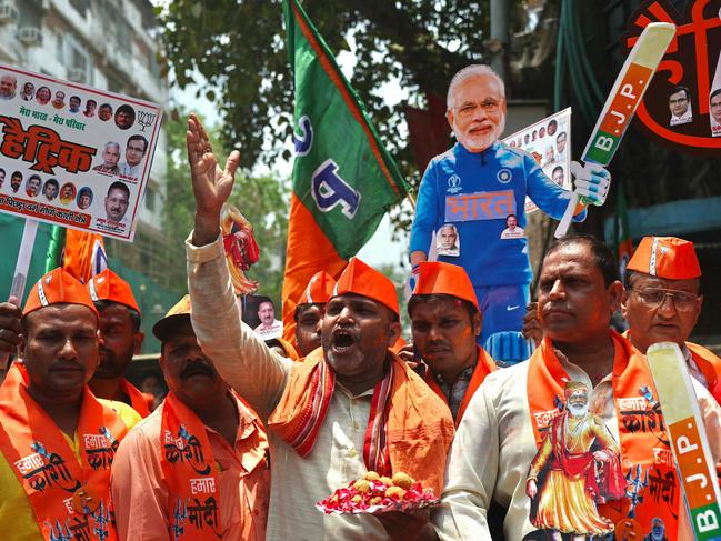 Supporters of Narendra Modi, India's Prime Minister and leader of Bharatiya Janata Party (BJP) carry his cut-out as they celebrate vote counting results for India's general election in Varanasi on June 4, 2024. Vote counting was underway in India's election on June 4, with Prime Minister Narendra Modi all but assured a triumph for his Hindu nationalist agenda that has thrown the opposition into disarray and deepened concerns for minority rights. (Photo by Niharika KULKARNI / AFP)