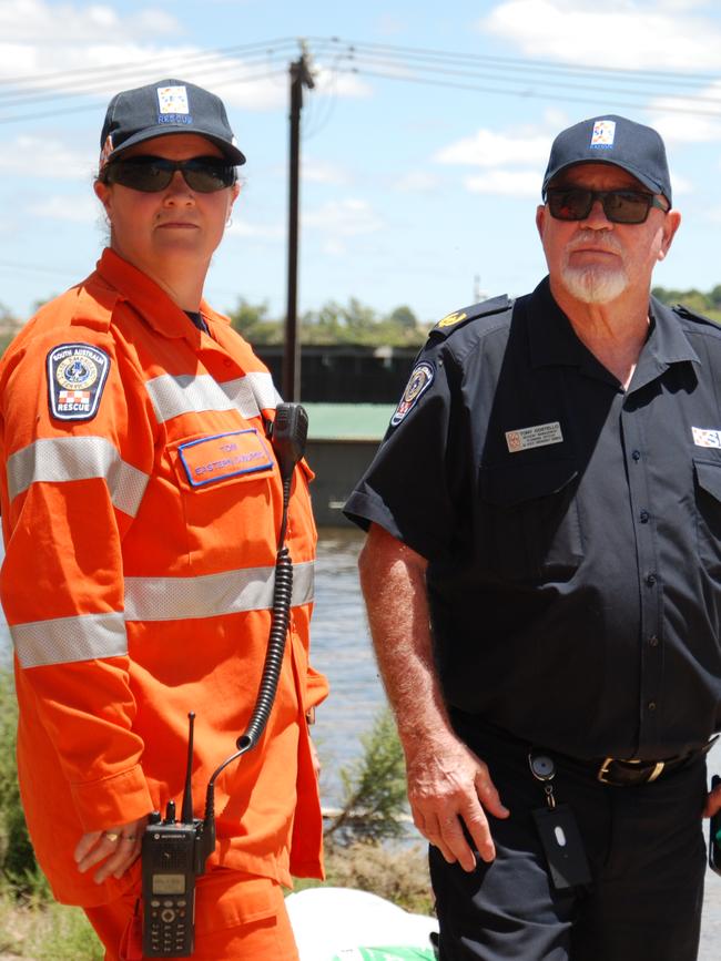 SES members Tony Costello and Toni Clarke stand by the flooded road leading to the SA Water pumping station at Cowirra which is set to be protected by 150 tonnes of sand flown in via helicopter.