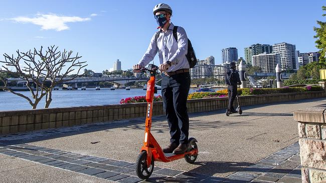 A person riding a scooter wears a mask at Southbank, Brisbane. Picture: Jono Searle/Getty Images