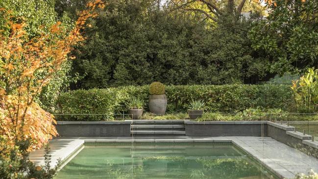 The solar-heated pool is set among greenery including elms and maples.