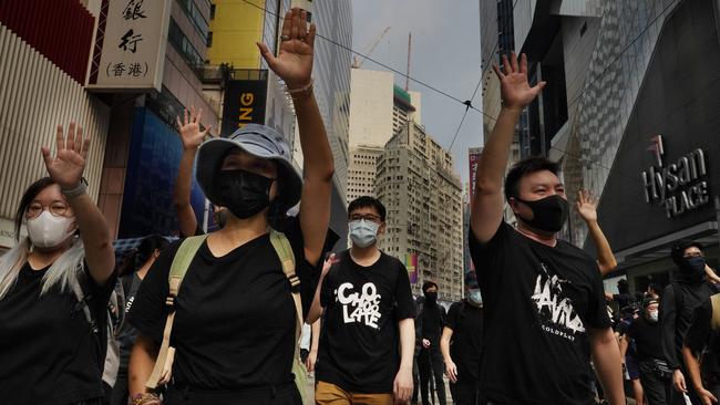 Protesters display opened palm with five fingers, signifying the five demands of protesters at a main street in Hong Kong.