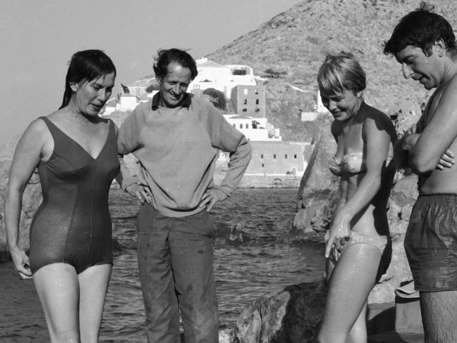 As their son Jason Johnston crawls in the sand, married Australian authors George Johnston (left) and Charmian Clift (second left) speak with Norwegian expatriate Marianne Jensen (also known as Ihlen) and Canadian poet, author, and musician Leonard Cohen at the beach, Hydra, Greece, October 1960. Cohen had bought a house on the island earlier in the year, while the others were established residents. Jensen inspired a number of Cohen's songs and poems.  (Photo by James Burke/The LIFE Picture Collection/Getty Images)