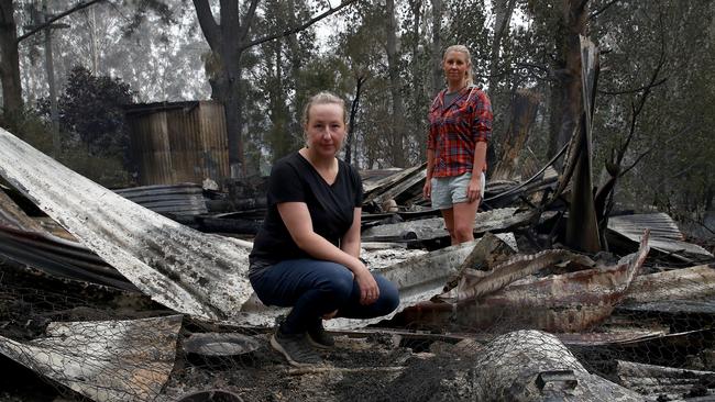 Bushfires on the far south coast of NSW. Allana Jones (L) and friend Hayley Lewis look through the remains of a shed that was burnt out on Allana's New Buildings Rd property near Wyndham after the Big Jack Mountain fire tore through the area. Picture: Toby Zerna