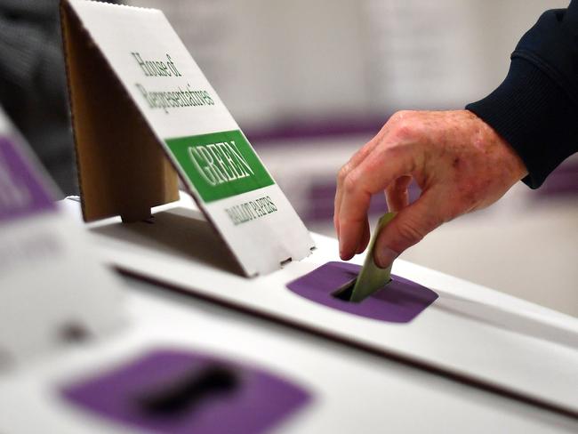 A voter drops her ballot paper into the ballot box at the Lilly Pilly polling booth during the Australia's general election in Sydney on May 18, 2019. (Photo by Saeed KHAN / AFP)