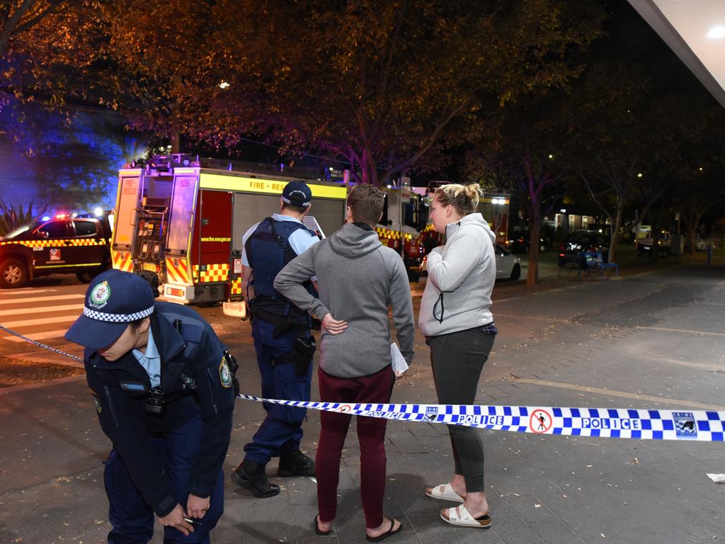 Worried residents evacuated from the complex in Sydney’s inner south speak to police outside the building. Picture: Flavio Brancaleone