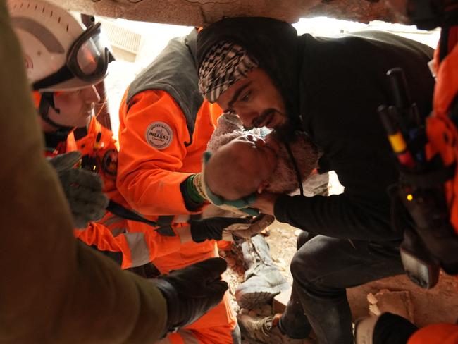 Members of the Swiss rescue team handing over a four-month-old girl called Abir rescued from under the rubble of a collapsed building following a massive earthquake on February 6, in Antakya, in Hatay province. Picture: AFP