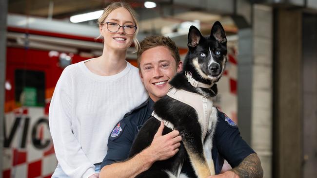 Firefighter Alex Eldridge with German Shepherd cross Husky puppy, Ember and partner Jordan Trabert. Picture: Jason Edwards