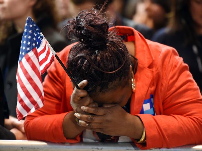 Marta Lunez, supporter of US Democratic presidential nominee Hillary Clinton, reacts to elections results during election night at the Jacob K. Javits Convention Center in New York on November 8, 2016. / AFP PHOTO / DON EMMERT