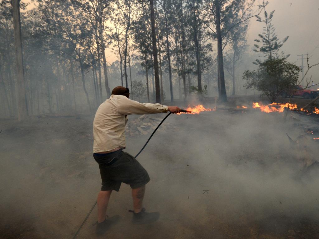 Residents and firefighters fight a bushfire that has threatened homes in Rainbow Flat on NSW Mid North Coast. Photo: Jeremy Piper