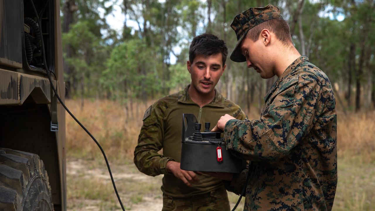 Australian Defence Force craftsman Jayden Eva (left), a recovery mechanic with 7th Combat Service Support Battalion, and U.S. Marine Corps Pfc. Kellan Royce, a motor transport operator with 3d Battalion, 12th Marines, 3d Marine Division, exchange tactical vehicle equipment knowledge during Talisman Sabre 2021 at Camp Growl, Shoalwater Bay Training Area, Queensland, Australia, July 13, 2021. This is the ninth iteration of Talisman Sabre, a large-scale, bilateral military exercise between Australia and the U.S. involving more than 17,000 participants from seven nations. The month-long multi-domain exercise consists of a series of training events that reinforce the strong U.S./Australian alliance and demonstrate the U.S. MilitaryÃ¢â&#130;¬â&#132;¢s unwavering commitment to a free and open Indo-Pacific. Eva is a native of Brisbane, Queensland, and Royce is a native of Santa Cruz, California. (U.S. Marine Corps photo by Lance Cpl. Ujian Gosun)