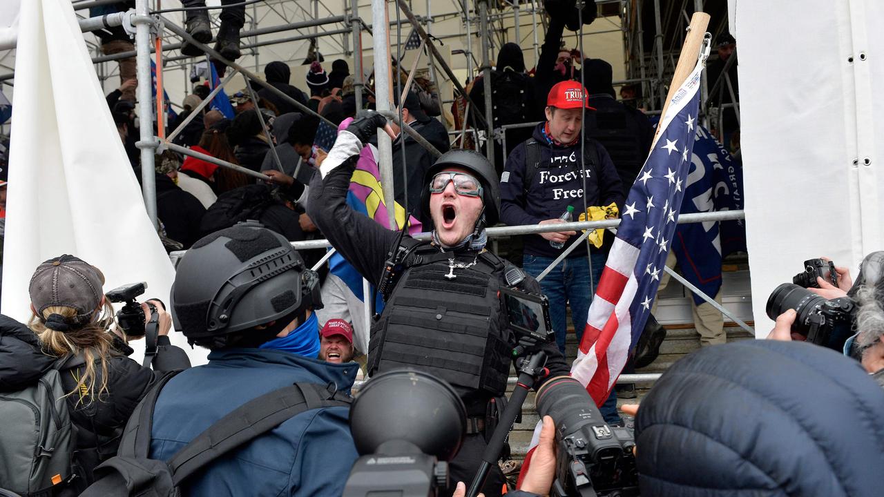 A man calls on people to raid the building as Trump supporters clash with police and security forces as they try to storm the US Capitol in Washington D.C.