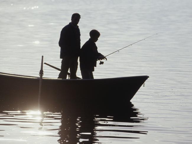 Silhouettes of father and son (13-14) standing in boat fishing Thinkstock image for The Courier-Mail CM2 fishing pointer on dangers of fishing, injuries etc. 30 August 2013 One time use only.