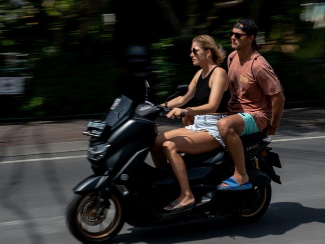 Tourists ride a motorcycle without helmets at a main road in Canggu, Bali, Indonesia. Picture: Getty Images