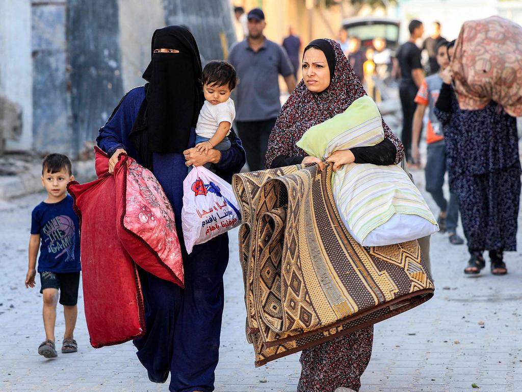 Palestinian women walk with children and belongings as they flee an area in the aftermath of an Israeli air strike in Rafah in the southern Gaza Strip. Picture: AFP