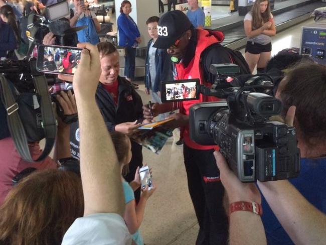 Gayle signs autographs as he arrives back in Melbourne