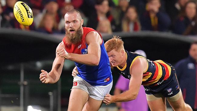 Max Gawn gets his handball away under pressure from Kyle Cheney.