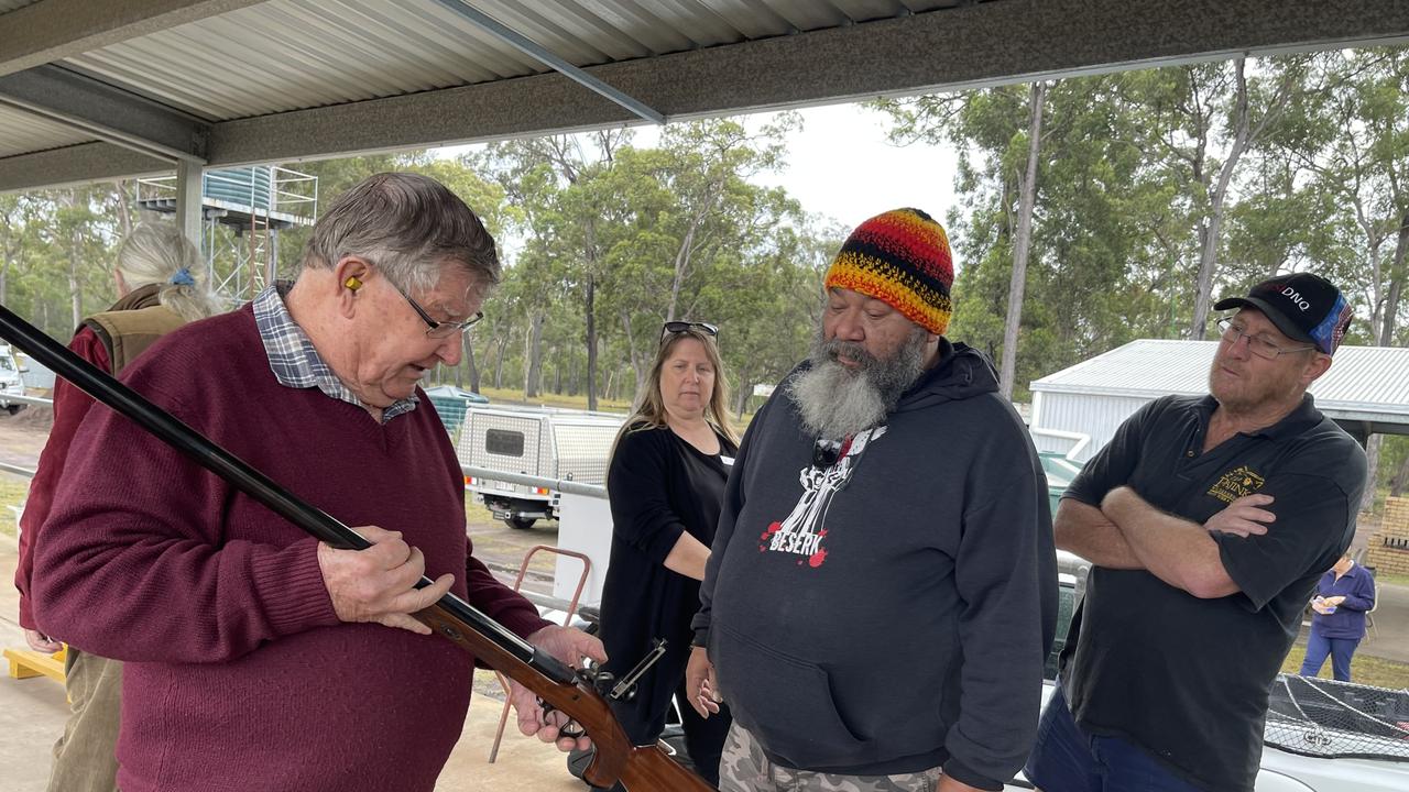 Shooter David Moon shows John Ellis the gun he will use to aim at the shields.