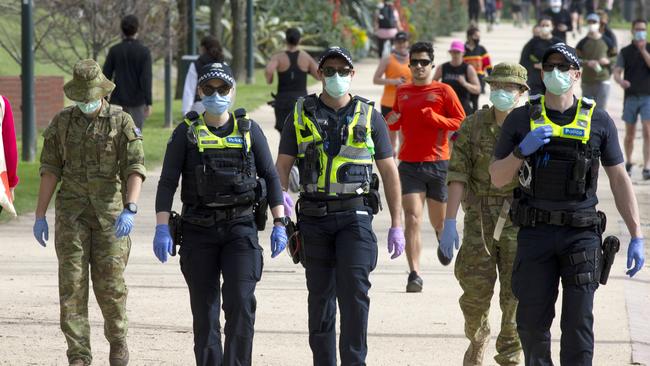 Police officers and army personnel patrol the Tan Track during stage 4 lockdown across Melbourne. Picture: NCA NewsWire / David Geraghty