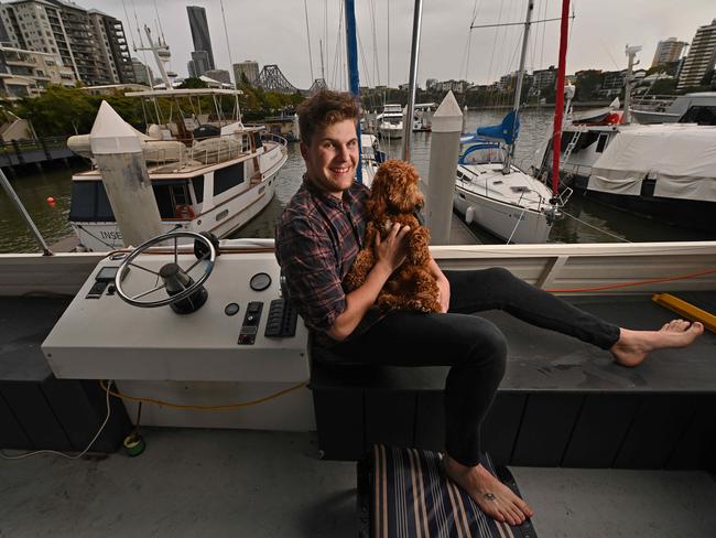 01/07/2021: Hospital worker Samuel Scott, 22, (with Ollie) more than happy that he has received his second dose of COVID-19 Vaccine AstraZeneca, on the houseboat he lives in on the Brisbane River at Kangaroo Point, Brisbane. . Pic Lyndon Mechielsen / The Australian