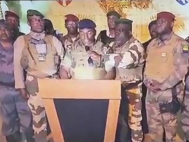 This video grab taken from Gabon 24 shows Gabonese soldiers appearing on television on August 30, 2023 announcing they were "putting an end to the current regime" and the cancellation of an election that, according to official results, President Ali Bongo Ondimba won. During the announcement, AFP journalists heard gunfire ring out in the Gabonese capital, Libreville. While announcing the cancellation of the results one of the soldiers announced the dissolution of "all the institutions of the republic".  "We have decided to defend peace by putting an end to the current regime", one of the soldiers said on TV channel Gabon 24, adding that he was speaking on behalf of the "Committee for the Transition and Restoration of Institutions". "To this end, the general elections of 26 August 2023 and the truncated results are cancelled," he added. "All the institutions of the republic are dissolved: the government, the Senate, the National Assembly and the Constitutional Court," he added, announcing the closure of the country's borders "until further notice". Among the soldiers were members of the Republican Guard as well as soldiers of the regular army and police officers. (Photo by Gabon 24 / AFP) / RESTRICTED TO EDITORIAL USE - MANDATORY CREDIT "AFP PHOTO / GABON 24" - NO MARKETING NO ADVERTISING CAMPAIGNS - DISTRIBUTED AS A SERVICE TO CLIENTS