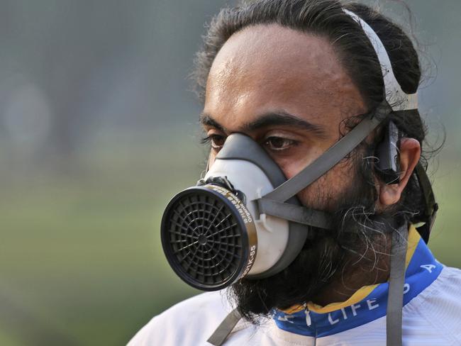 A participant wears a mask as he runs during the Delhi Half Marathon in New Delhi, India, Sunday, Nov. 19, 2017. Ethiopia's Birhanu Legese and Almaz Ayana won the men's and women's elite categories, respectively. (AP Photo/Oinam Anand)