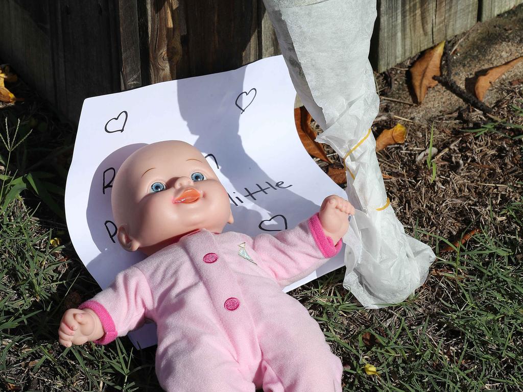 Flowers, doll and a note left at the house of the victims of a fatal car fire. Picture: Liam Kidston