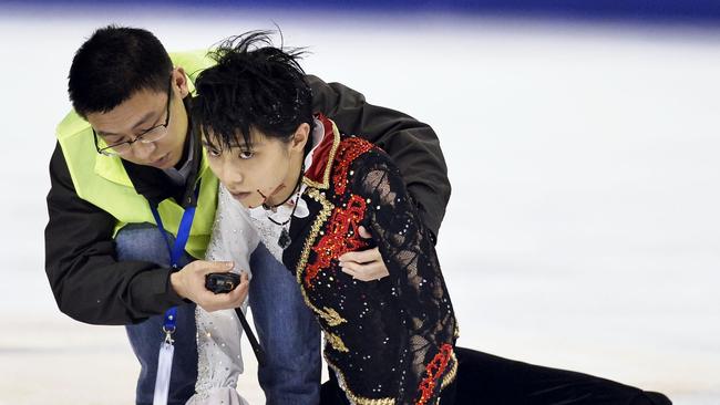 Japanese ice skater Yuzuru Hanyu is assisted by medical staff after clashing with Yan Han of China during a practice prior to their free program performance at the Cup of China in Shanghai in November, 2014. Picture: AP