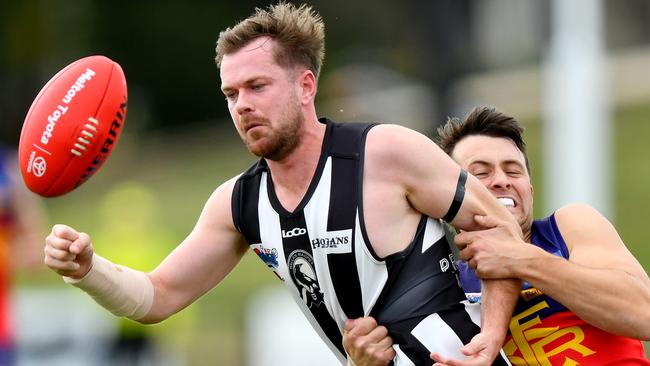 Sean Morris tries to handball for Wallan. Picture: Josh Chadwick